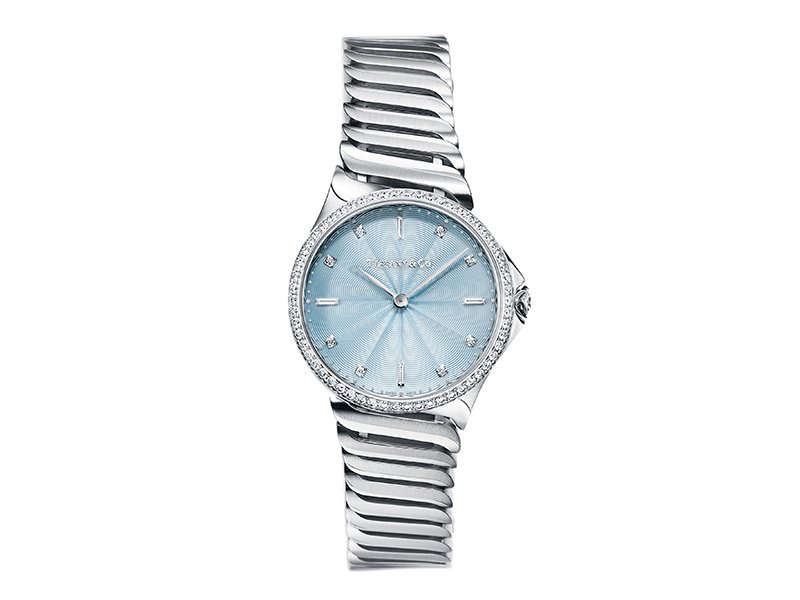 Tiffany & Co’s Metro collection features watches in a variety of styles and colors. In this version, the case is set with round brilliant diamonds, and the dial is a lacquered ice-blue color with flinqué finishing. Every watch has a serialized diamond on the crown.