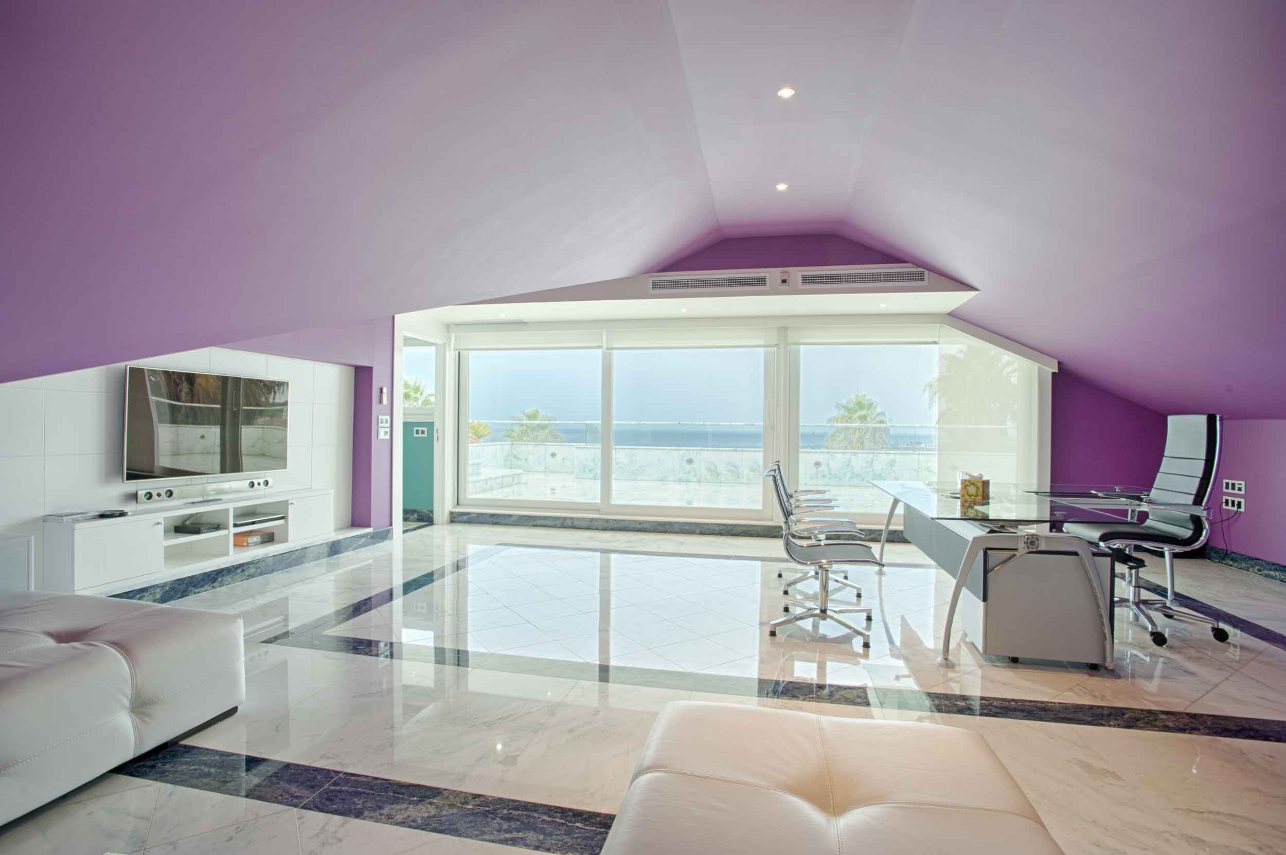 This five-story residence on the southern coast of Portugal is vividly decorated throughout. The lower-level office has a bright purple palette, which creates contrast with the alluring views of sea and sky.
