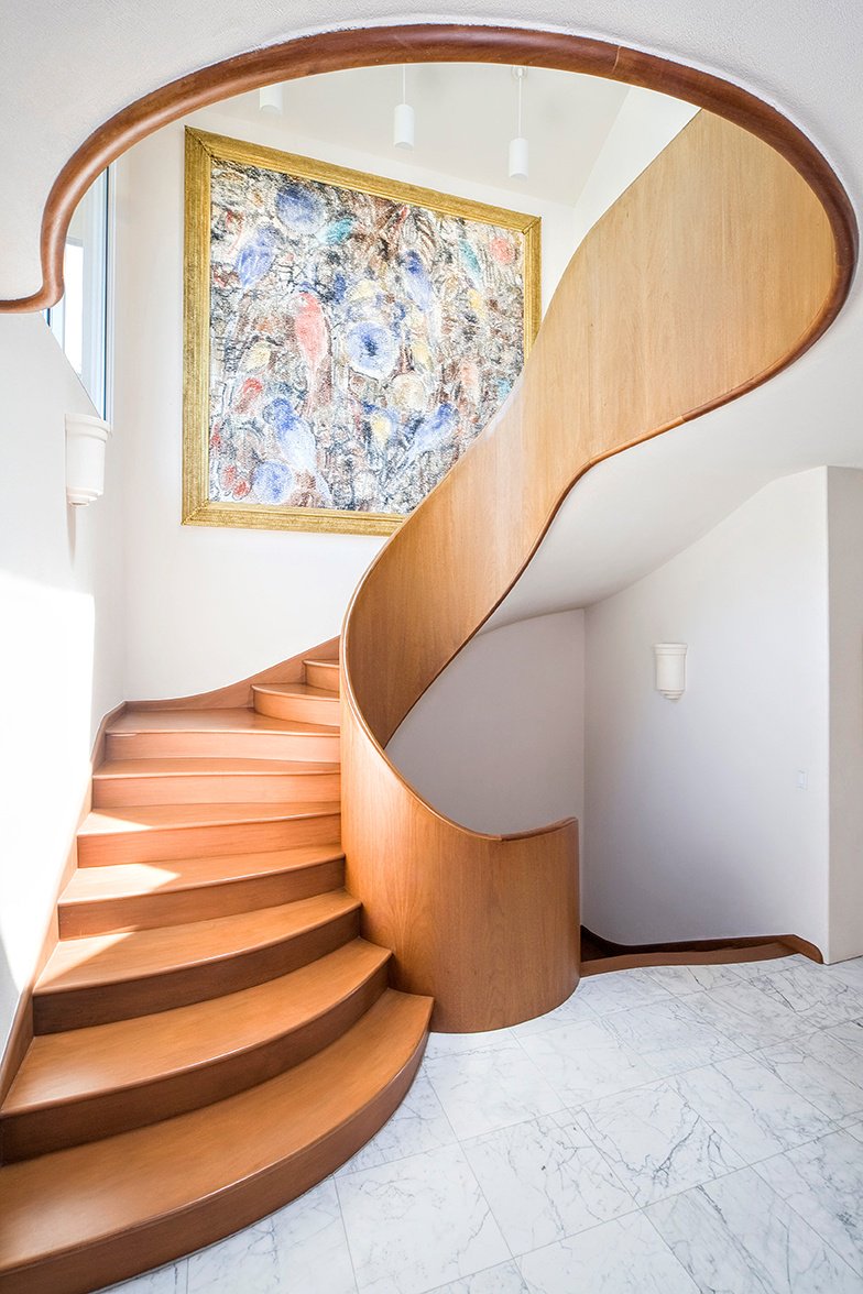 The sculpted wood staircase is among the home’s many artisanal touches.