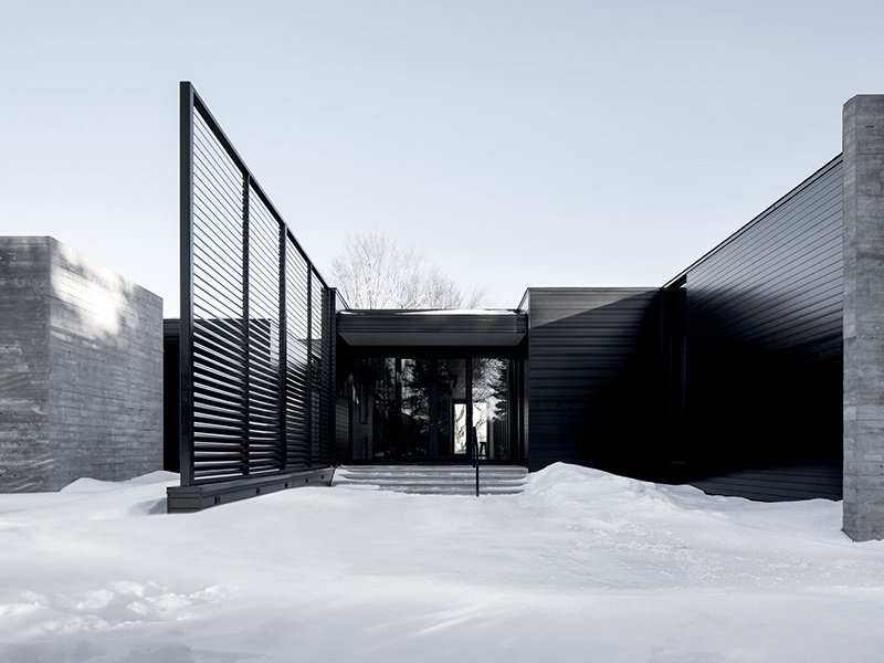 The metal and glass exterior of Alain Carle Architecte's True North residence, in rural Ontario, Canada, reflects light and creates shadows so the appearance of the building constantly shifts and reshapes.