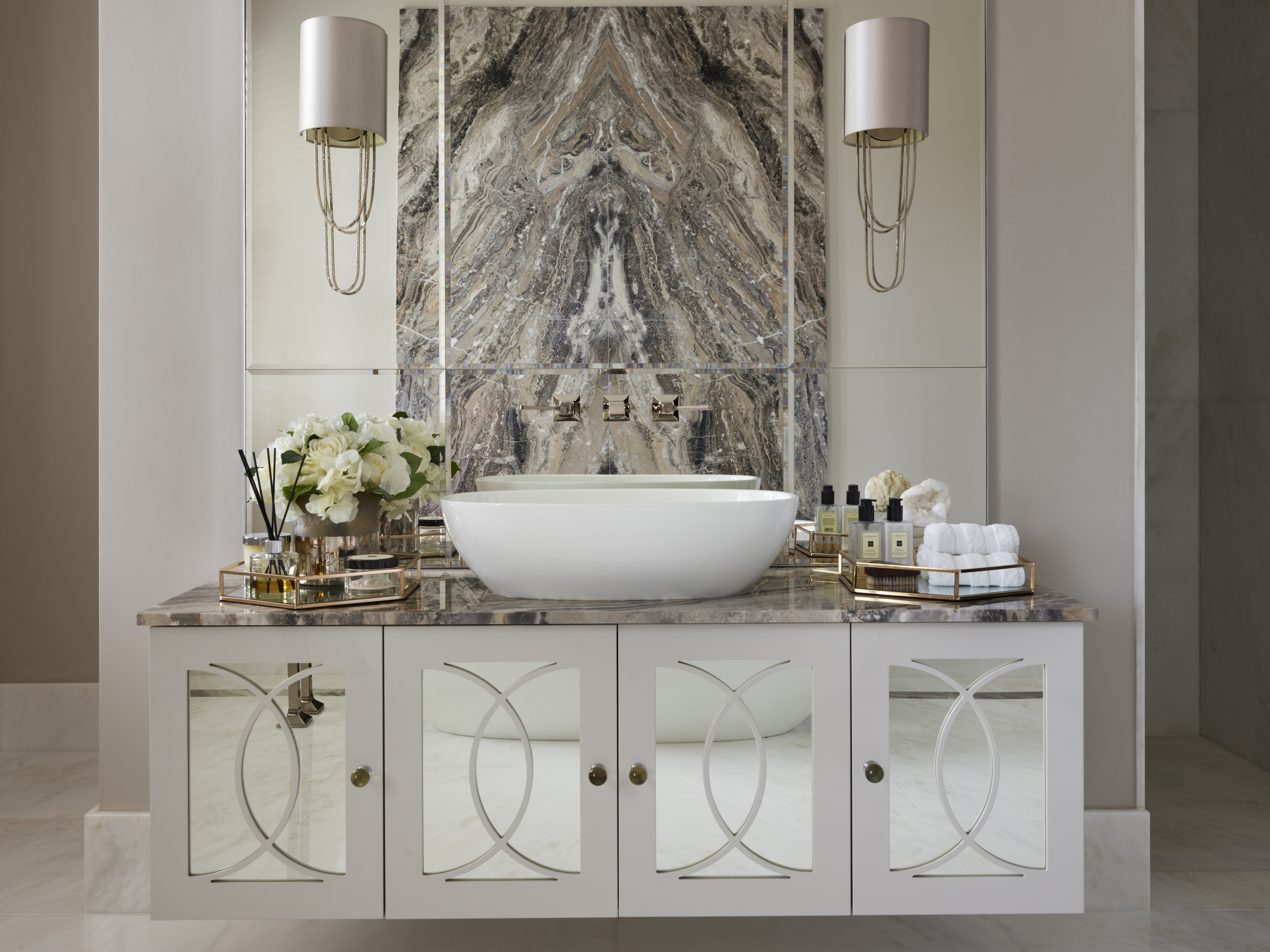 A veined slab of marble reflected in the mirror of a grand bathroom