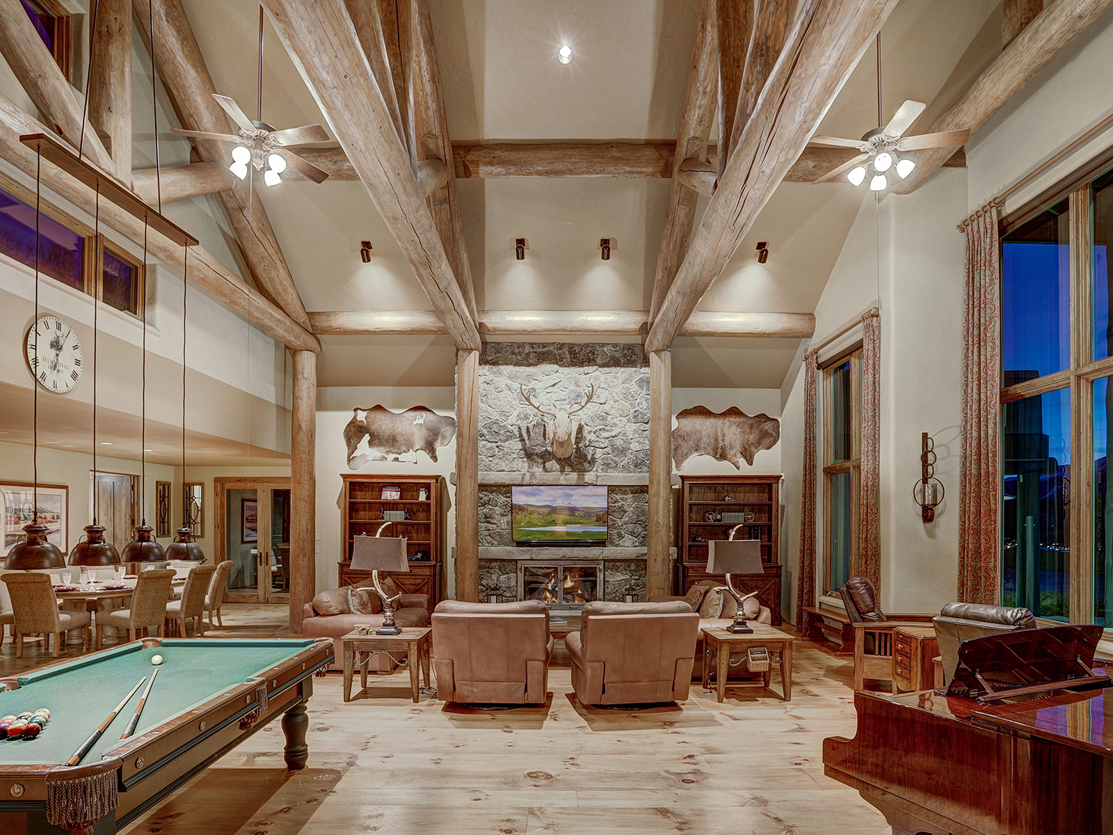 Double height lounge featuring a pool table, piano, and fireplace