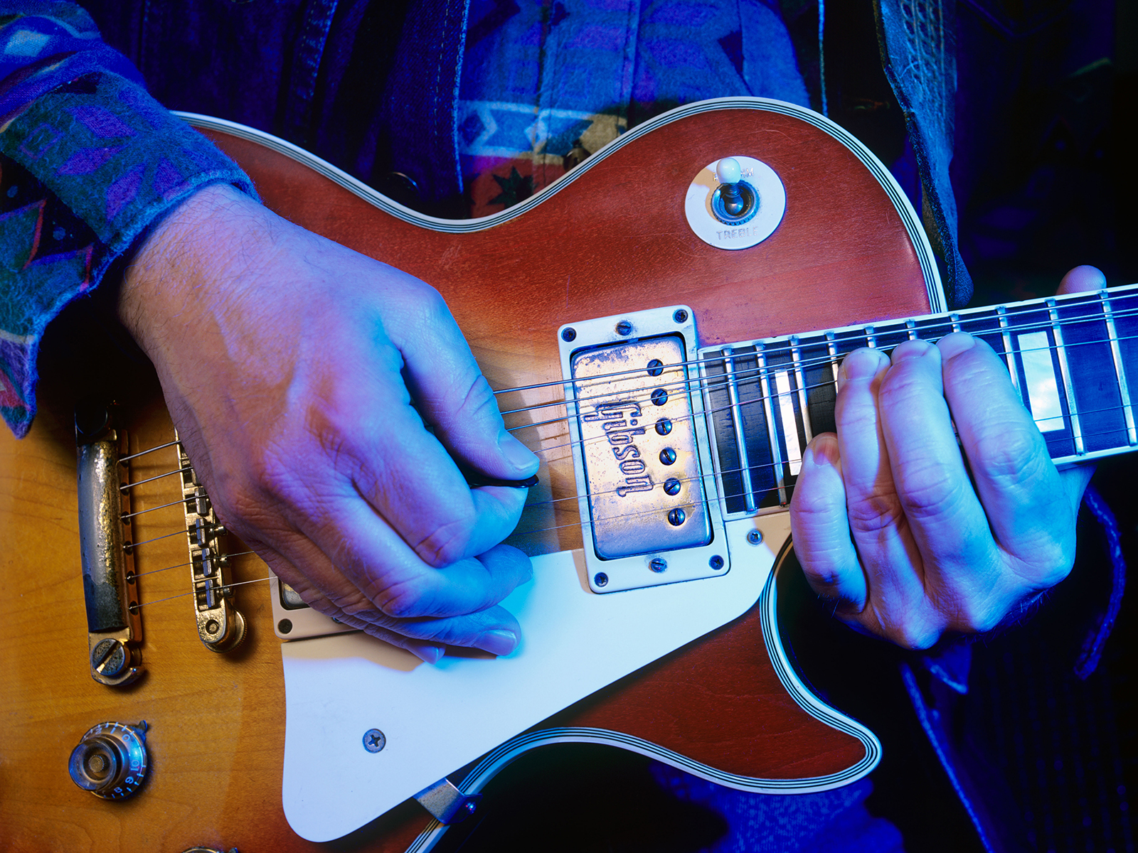 Close up of hands playing a 1970 red sunburst Gibson Les Paul guitar