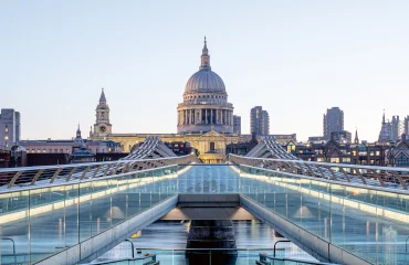 The domed roof of St. Paul's Cathedral in London viewed from the modern Millennium Bridge